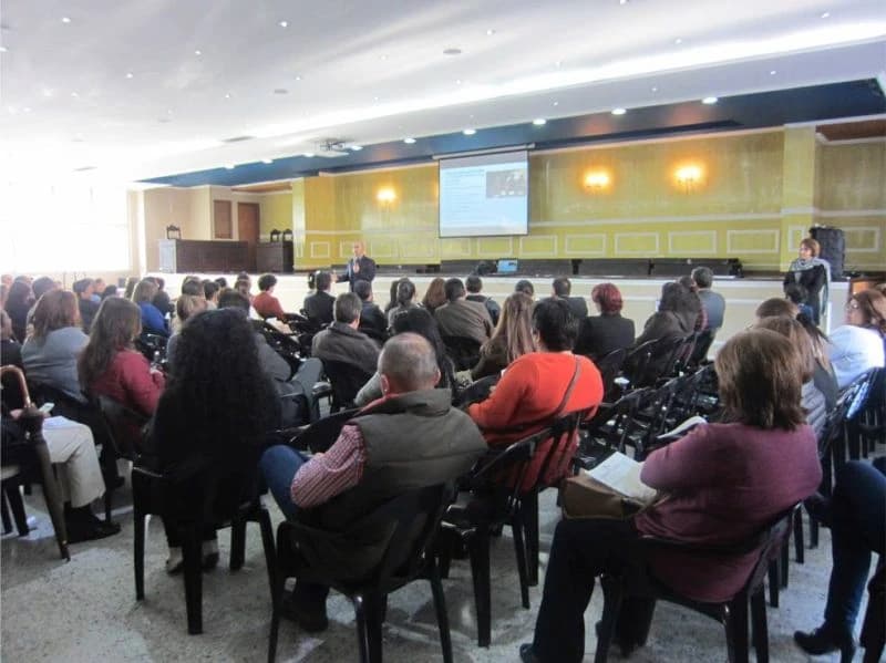 Salón de eventos lleno de asistentes durante una conferencia de prevención