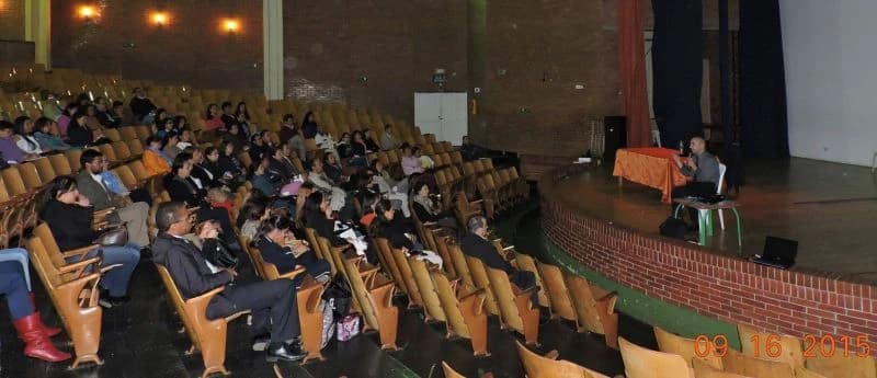 Teatro escolar con estudiantes y padres durante una charla de prevención
